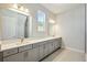 Bathroom featuring double sinks, gray cabinetry, and a tile floor at 17525 Glistening Ct, Venice, FL 34293