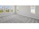 Bright bedroom featuring neutral carpet and large windows overlooking the landscaped yard at 17525 Glistening Ct, Venice, FL 34293