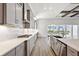 Bright kitchen with stainless steel appliances, stone countertops, and view of the pool at 17525 Glistening Ct, Venice, FL 34293
