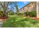 Landscaped backyard with manicured lawn and mature trees bordering the home at 1858 Longview Ln, Tarpon Springs, FL 34689