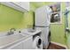 Laundry room with washer, dryer, utility sink, and shelving at 1858 Longview Ln, Tarpon Springs, FL 34689