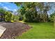 Spacious backyard with lush landscaping and a partially covered patio at 1858 Longview Ln, Tarpon Springs, FL 34689
