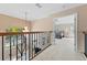 Upstairs hallway with wood and wrought iron railings overlooking the living room at 1858 Longview Ln, Tarpon Springs, FL 34689