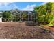 View of the backyard with a bird feeder and mulch beds at 1858 Longview Ln, Tarpon Springs, FL 34689