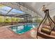 Relaxing pool area featuring a covered patio and wicker swing at 2516 Roberta St, Largo, FL 33771