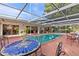 Outdoor oasis with a refreshing pool, patio table, and vibrant sunflowers at 2516 Roberta St, Largo, FL 33771