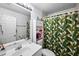 Clean bathroom with white vanity, shower, and tropical shower curtain at 3332 W Heiter St, Tampa, FL 33607