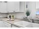 Kitchen sink and countertop detail with granite and white cabinets at 4900 Brittany S Dr # 314, St Petersburg, FL 33715