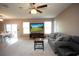 Bright living room featuring a large TV, comfortable seating, and ample natural light at 8519 Sunshower Pl, Parrish, FL 34219