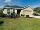 Tan house with two-car garage and landscaped yard at 8519 Sunshower Pl, Parrish, FL 34219