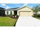 Tan house with two-car garage and landscaped yard at 8519 Sunshower Pl, Parrish, FL 34219