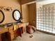 Bathroom featuring double sinks with framed mirrors, an open vanity and glass block shower at 15918 Redington Dr, Redington Beach, FL 33708