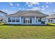 Spacious backyard featuring a well-maintained lawn and covered patio at 18096 Foxtail Loop, Venice, FL 34293