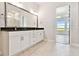 Bright bathroom boasts double vanity with black countertop and stylish hexagon tile flooring at 18096 Foxtail Loop, Venice, FL 34293