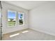 Bright bedroom featuring plush carpeting and windows offering serene outdoor views at 18096 Foxtail Loop, Venice, FL 34293