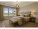 Serene bedroom featuring large windows with beautiful lake views and neutral tones at 18096 Foxtail Loop, Venice, FL 34293