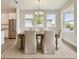 Bright dining room area with wooden table, six chairs, and stainless steel refrigerator at 18096 Foxtail Loop, Venice, FL 34293