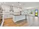 Modern, white kitchen with stainless steel appliances and a large island at 18096 Foxtail Loop, Venice, FL 34293