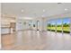 Open-concept living room with wood floors, stainless steel appliances and lake view at 18096 Foxtail Loop, Venice, FL 34293