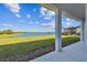 Covered patio with serene lake views and lush green lawn at 18096 Foxtail Loop, Venice, FL 34293