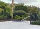 Small round spa with a metal railing, surrounded by lush tropical landscaping at 29254 Bay Hollow Dr # 3262, Wesley Chapel, FL 33543