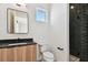 Modern bathroom with a sleek vanity, dark subway tile shower, and stylish mirror at 3035 1St S Ave, St Petersburg, FL 33712