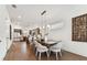 Dining room with hardwood floors, a long dining table, and modern lighting fixtures, leading to a kitchen at 3035 1St S Ave, St Petersburg, FL 33712