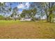 Rear view of a white brick ranch home showcasing a large backyard at 4401 Platt Rd, Plant City, FL 33565