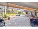 Relaxing screened patio with paver stones, string lights, and outdoor seating at 5479 Blue Heron Ln, Wesley Chapel, FL 33543