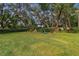 Landscaped backyard with tropical plants and large trees at 5479 Blue Heron Ln, Wesley Chapel, FL 33543