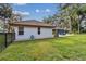 White house exterior with brown tile roof, green lawn, and a black fence at 5479 Blue Heron Ln, Wesley Chapel, FL 33543
