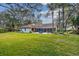 View of house exterior with lush green lawn and mature trees at 5479 Blue Heron Ln, Wesley Chapel, FL 33543