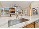 Modern kitchen features a large island with quartz countertops and stainless steel sink at 5479 Blue Heron Ln, Wesley Chapel, FL 33543