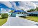 Light blue mobile home with a deck and driveway at 6028 Ridgewood Dr, Zephyrhills, FL 33542