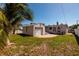 A backyard with a brick patio and a detached one-car garage next to a home on a sunny day at 615 78Th Ave, St Pete Beach, FL 33706