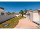 Backyard featuring a spacious driveway, palm trees, and a white fence, creating a private outdoor space at 615 78Th Ave, St Pete Beach, FL 33706