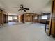 Spacious, gutted living room showing an open floor plan with a tiled floor and ceiling fans at 615 78Th Ave, St Pete Beach, FL 33706