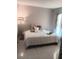 Cozy bedroom with tiled floors, decorative pillows, and a floor lamp for added ambiance at 9708 Little Pond Way, Tampa, FL 33647