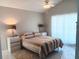 Comfortable bedroom with neutral tones, tiled floors, and a ceiling fan with decorative lighting at 9708 Little Pond Way, Tampa, FL 33647