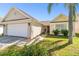 Front view of a single-story house with a two-car garage and lush landscaping at 9708 Little Pond Way, Tampa, FL 33647