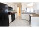White kitchen with granite counters, black appliances, and ample storage at 9708 Little Pond Way, Tampa, FL 33647