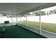 Screened patio with green carpet and backyard views, creating an ideal outdoor living space at 9708 Little Pond Way, Tampa, FL 33647