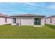Private backyard with grass lawn and sliding glass door access at 29596 Fedora Cir, Brooksville, FL 34602