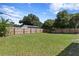 Large grassy backyard with a wooden fence at 311 80Th Ne Ave, St Petersburg, FL 33702