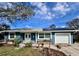 Blue house with solar panels, white garage door, and landscaping at 311 80Th Ne Ave, St Petersburg, FL 33702
