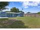 Large grassy backyard with a patio and wooden fence at 311 80Th Ne Ave, St Petersburg, FL 33702