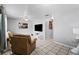 Living room featuring tiled floors, comfortable seating, and a large TV at 3334 W Heiter St, Tampa, FL 33607