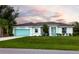 Newly built home with teal garage door and manicured lawn at 411 Seasons Dr, Punta Gorda, FL 33983