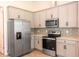 Modern kitchen with gray cabinets and stainless steel appliances at 411 Seasons Dr, Punta Gorda, FL 33983