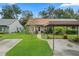 House exterior showcasing a carport and nicely landscaped front yard with tropical plants at 6126 Beechwood Dr, Dade City, FL 33523